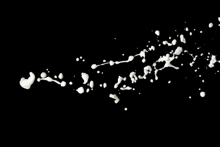 milk splash isolated on black backgroundの写真素材