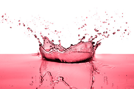 splashing red wine on white backgroundの写真素材