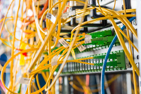 detail of server rack with fiber optic cables attached to front panel switch ports