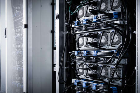 A row of racks with data storage hardware inside server room