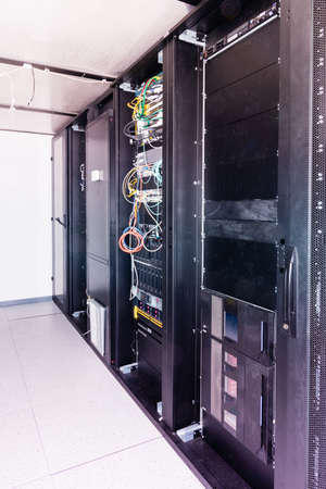 A row of racks with data storage hardware inside server room