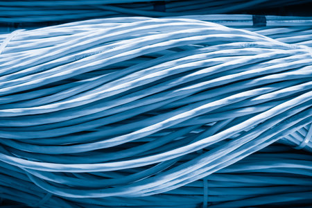 detail of large number of cables tied together connecting racks inside server room