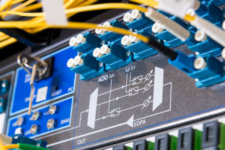 fiber optic cables plugged in network switch panel inside data centerの写真素材