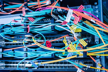 detail of server rack with fiber optic cables attached to front panel switch ports