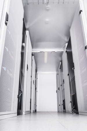 A row of racks with data storage hardware inside server room