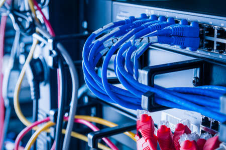 detail of large number of cables tied together connecting racks inside server room