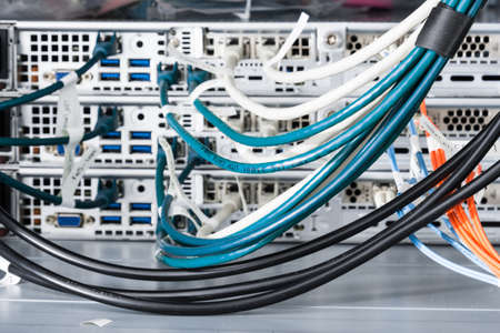 detail of large number of cables tied together connecting racks inside server room