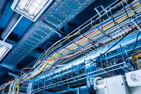 detail of large number of cables tied together connecting racks inside server room