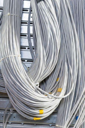 detail of large number of  cables tied together connecting racks inside server room