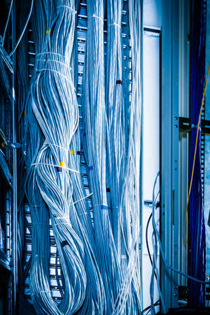 detail of large number of cables tied together connecting racks inside server room