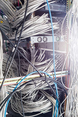 server room rack with tangled network cables creating messy untidy network system