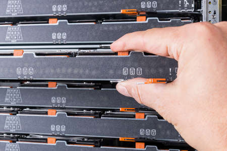 network administrator installing data storage hardware from sever rack