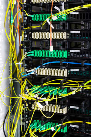 Fiber Optic cables connected to an optic ports - data switch in internet data centerの写真素材