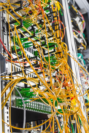 detail of server rack with fiber optic cables attached to front panel switch ports