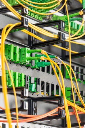 detail of server rack with fiber optic cables attached to front panel switch ports