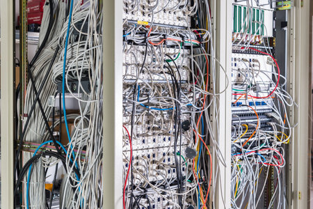 server room rack with tangled network cables creating messy untidy network systemの写真素材