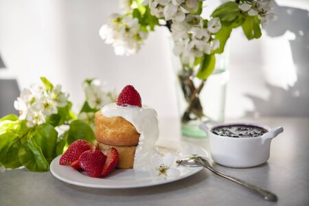 Japanese pancakes for brunch on a sunny spring day. Flowering pear branches and a beautiful breakfast with berriesの写真素材