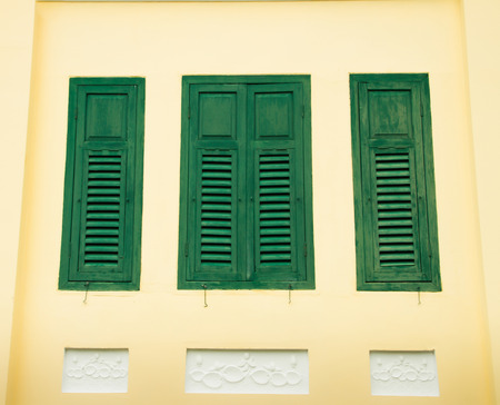 Antique wooden windows on building wall of 96 years of ageの写真素材