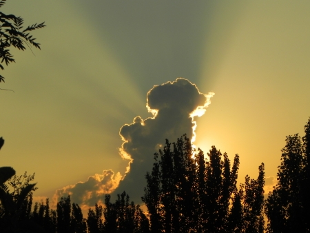 The rays of the setting sun breaking through the clouds の写真素材