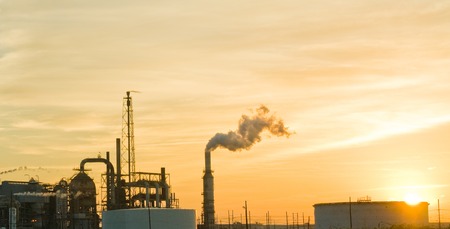 Sun setting behind an oil processing plant in Texas, USAの写真素材