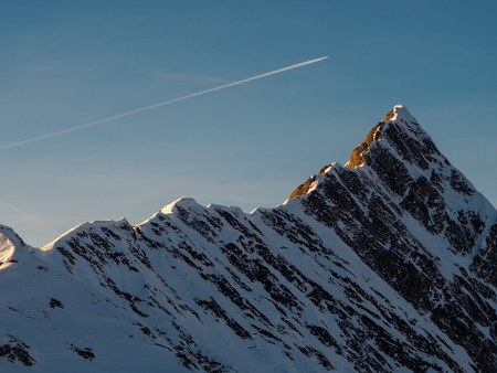 Airplane train above the dramatic Tuxer Joch peak in Austrian Alpsの写真素材
