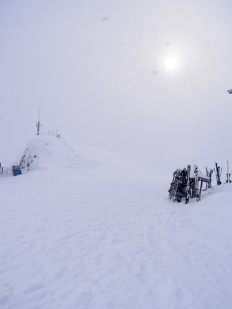 Skis and snowboards in rack during heavy snowfall wil limited visibilityの写真素材