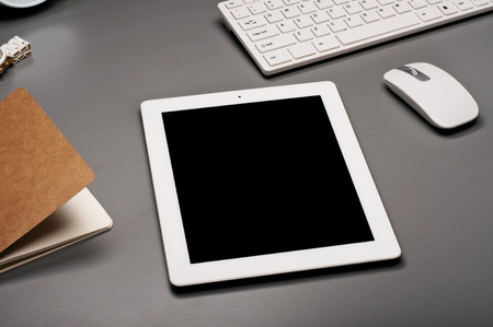 White tablet computer on a gray surface.の写真素材