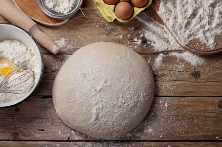 The dough in the form of a loaf of bread on a wooden table in a bakery.の写真素材