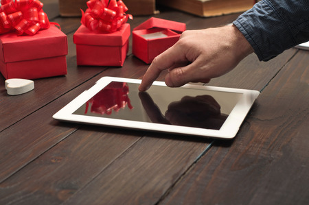 Closeup of a man clicks on screen tablet computer.