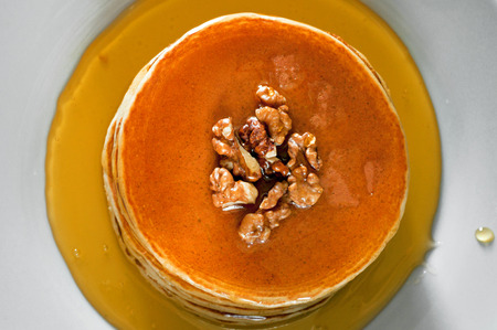 breakfast of pancakes on a white plate. Pancakes drenched with honey