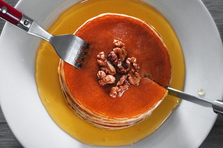 breakfast of pancakes on a white plate. Pancakes drenched with honey