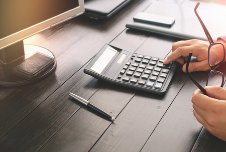 Businessman counting taxes sitting at office tableの写真素材