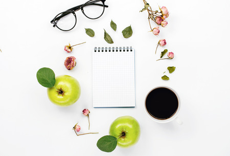 sketchbook with cup coffee, green apples with leaves, dry rose flowers and glasses. Flat lay, top viewの写真素材