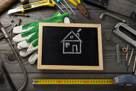 On wooden table in the workshop old tools and drawn house, top viewの写真素材