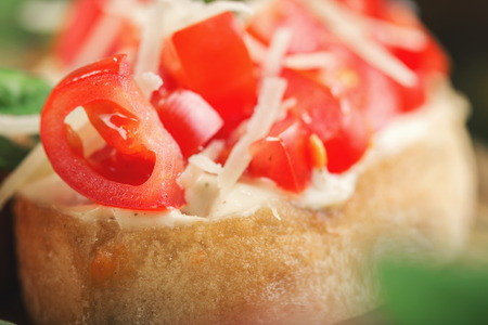 Bruschetta with tomatoes and parmesan cheese close up. Italian snack for wineの写真素材