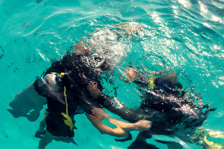 Couple divers plunged into the ocean, top view, close upの写真素材