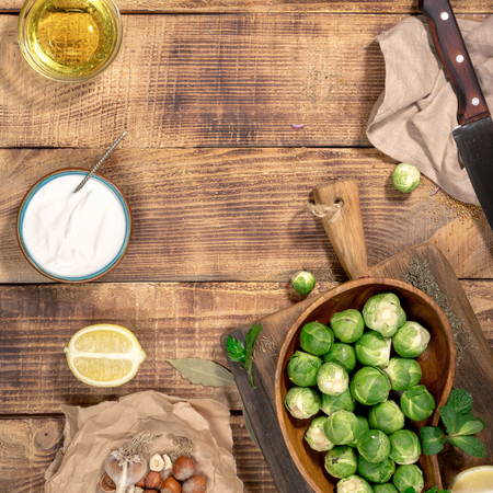 Frame of brussels sprouts with ingredients for cooking tasty and healthy food on wooden table, top view. Healthy foodの写真素材