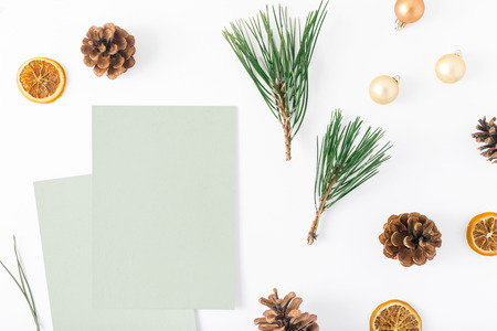 Blank cards with branch of Christmas tree, pine cones, dry orange and Christmas balls on white...