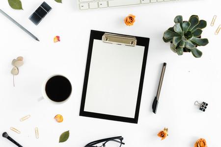 Home office workspace. Feminine workplace with clipboard, dry roses, keyboard, notepad, glasses,...