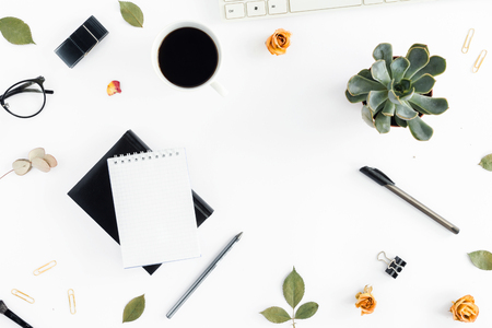 Home office workspace. Feminine workplace with dry roses, keyboard, notepad, succulents, pen and cup of coffee. Office table desk. Top view. Flat layの写真素材