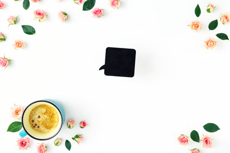 Frame of cup of coffee, pink rose and green leaves on white background, top viewの写真素材