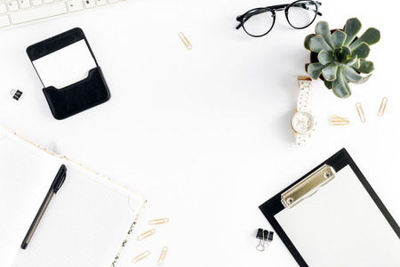 Home office workspace. Feminine workplace with clipboard, keyboard, notepad, glasses, succulents, watches and business card holder. Office table desk. Top view. Flat layの写真素材