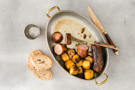Top view fried sausages with pumpkin in frying pan on a light surfaceの写真素材