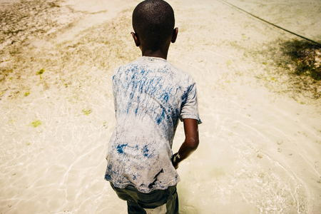 African child in search of seafood in the ocean