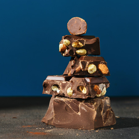 Dark chocolate stack on a blue background with copy spaceの写真素材