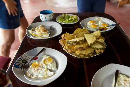 Breakfast table with fried eggs and fruits.の写真素材