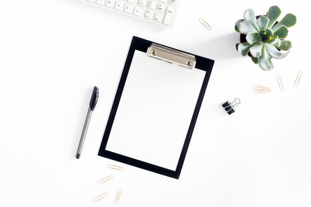 Feminine desk workspace with clipboard, keyboard, golden clips, pen and succulent on white background. flat lay, top viewの写真素材