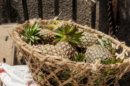 Heap of pineapples in a straw basket on the market in a stone town, Tanzania, Zanzibarの写真素材