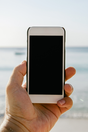 Male hand holding smartphone with blank screen close upの写真素材