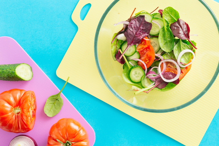 Close up bowl fresh summer salad on blue background, top view. Healthy food concept. Diet foodの写真素材